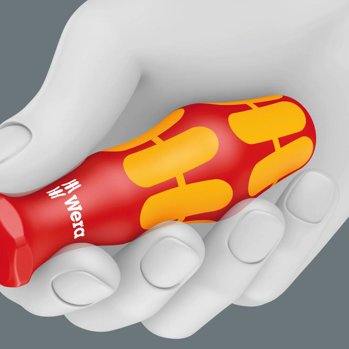 Hand gripping a red and yellow Wera Kraftform VDE insulated screwdriver handle showing ergonomic shape